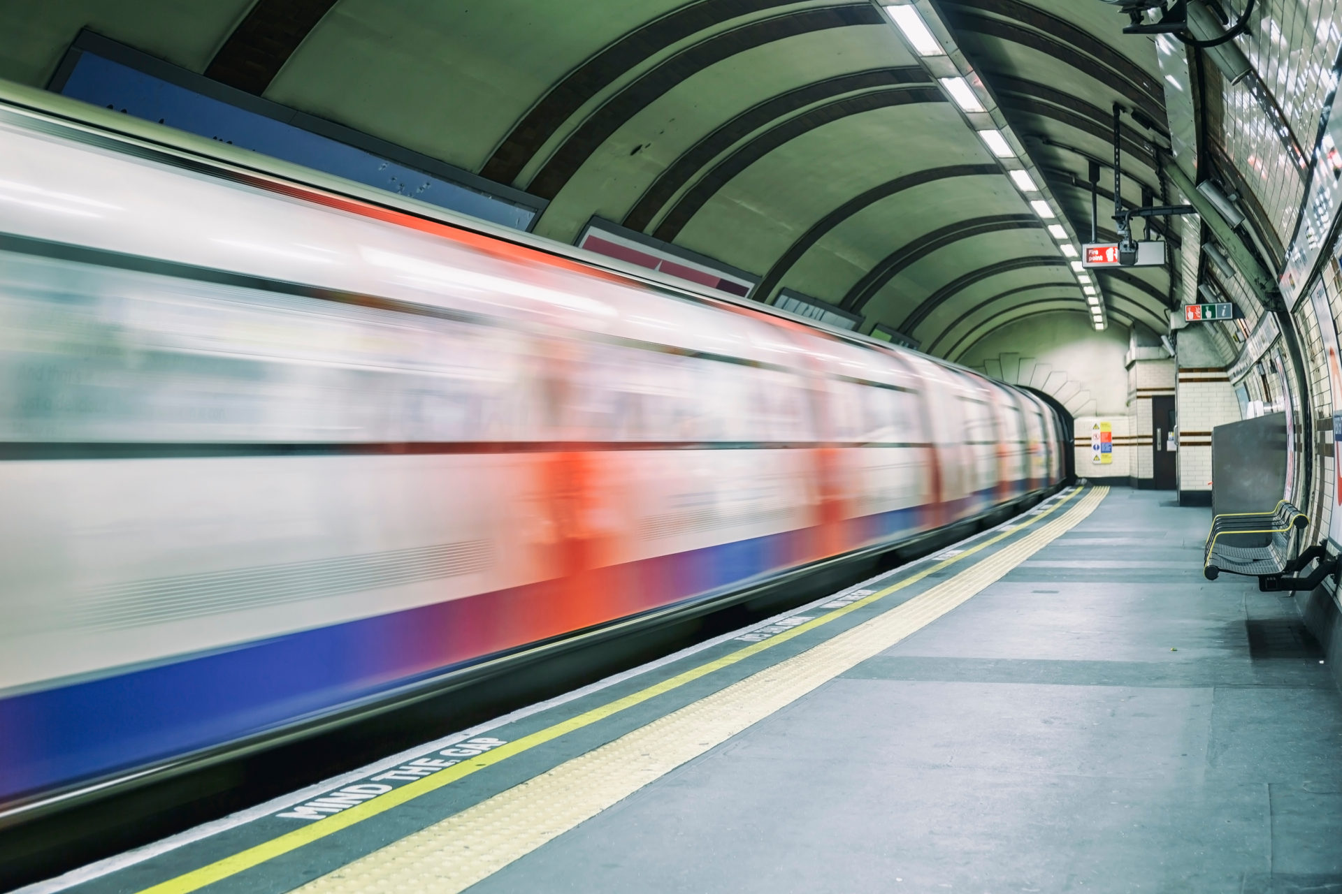 Tube leaving the platform at an underground station in London.